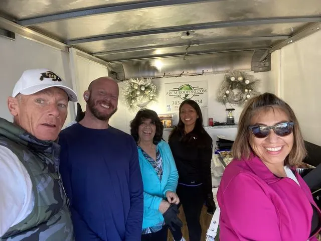 ARCM Roofing team and volunteers serving holiday meals from the ARCM trailer in Denver