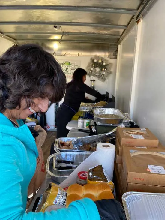ARCM Cares volunteer packing Thanksgiving rolls, sides and pumpkin pies in the ARCM food trailer