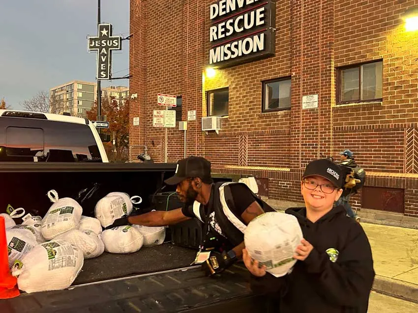 ARCM Roofing volunteers handing out turkeys outside the Denver Rescue Mission